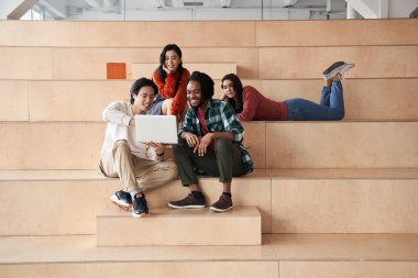 Dört farklı sınıf arkadaşı eğleniyor ve yüksek sesle gülüyor.