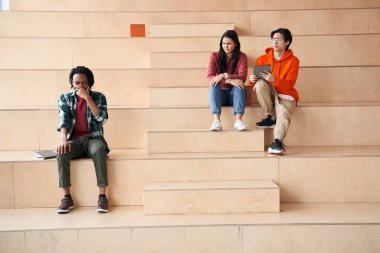 Kolunda öksüren çok ırklı erkek öğrenci.