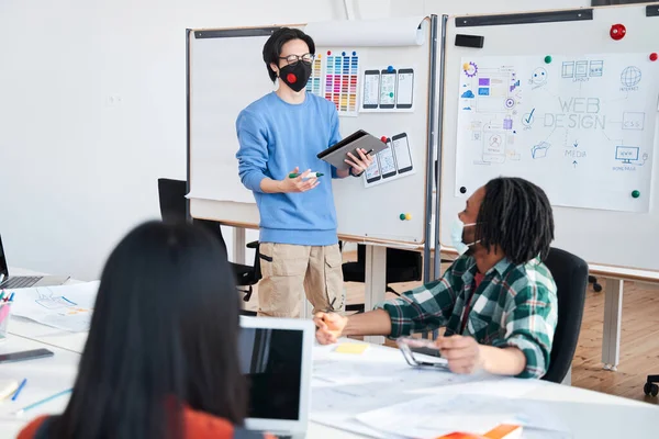 Motivato team leader maschile indossando maschera protettiva tenuta riunione — Foto Stock