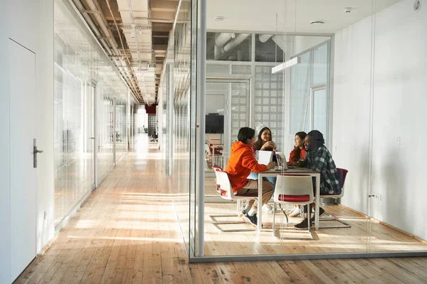 Equipo creativo de jóvenes diseñadores que trabajan en interiores utilizando un ordenador portátil y aparatos modernos —  Fotos de Stock