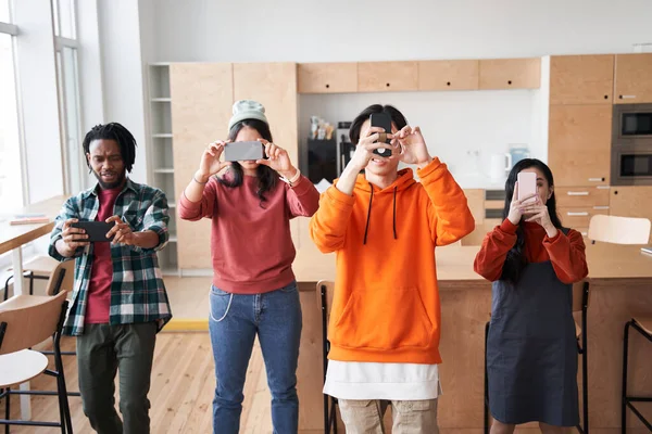 Beyaz tahtanın önünde durup ateş eden bir grup öğrencinin ön görüntüsü.