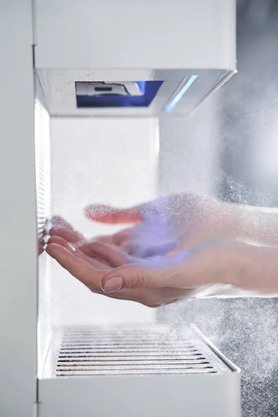 Washing hands using automatic sanitizer dispenser