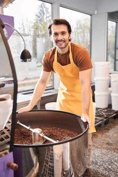 Mannen som kontrollerar bruna bönor häller i kylaren — Stockfoto