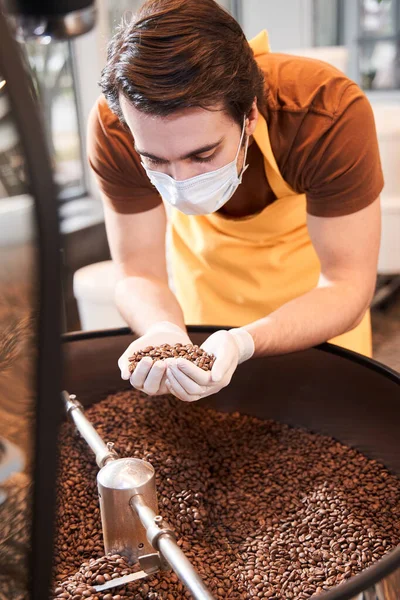 Koruyucu maske takan usta kahve çekirdeği kokluyor.