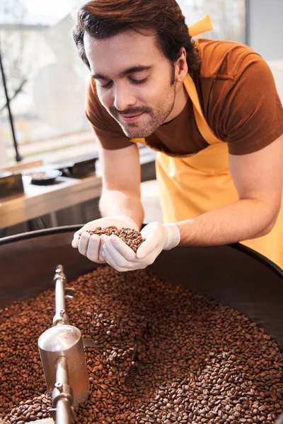 Homem cheirando grãos de café — Fotografia de Stock