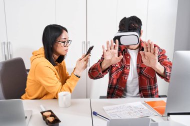 Tasarımcı VR gözlüklü masada oturuyor.