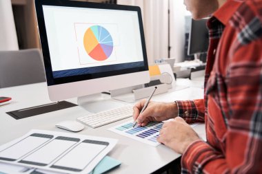 Tasarım stüdyosunda renk örnekleri seçen adam