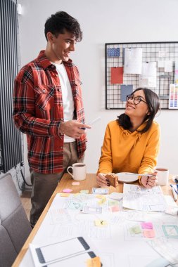 Tasarımcılar öğle yemeğinde birlikte çalışıyorlar.