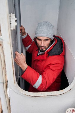 Balıkçı merdivenlerden inip güvertedeki kulübeye gidiyor.