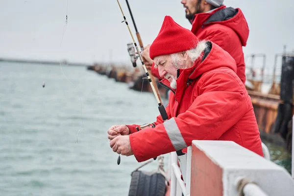Συνάδελφοι στέκονται σε μια βάρκα με καλάμι ψαρέματος και πιάνουν το δόλωμα — Φωτογραφία Αρχείου