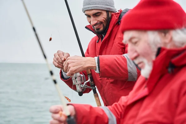 Collèges debout sur un bateau avec canne à pêche et crochet de l'appât — Photo