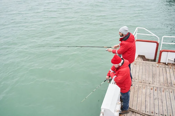 부지런 히낚는 사람이 거대 한 물고기를 잡도록 돕는 선원 — 스톡 사진