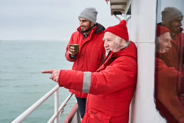 Pescatore mostrando qualcosa al suo collega sulla barca — Foto Stock