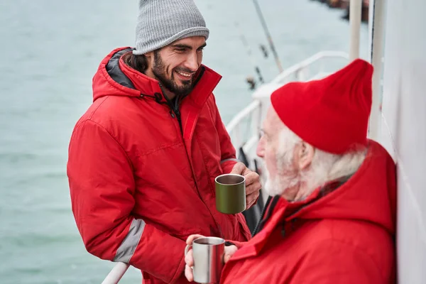 Zwei Kollegen trinken morgens Kaffee auf dem Boot — Stockfoto