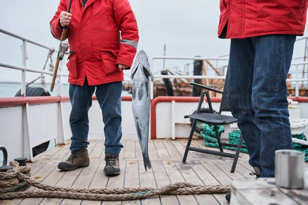 Fishermans sosteniendo su captura de peces en la caña — Foto de Stock