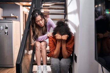 Kadın merdivenlerde otururken en iyi arkadaşını sakinleştiriyor.