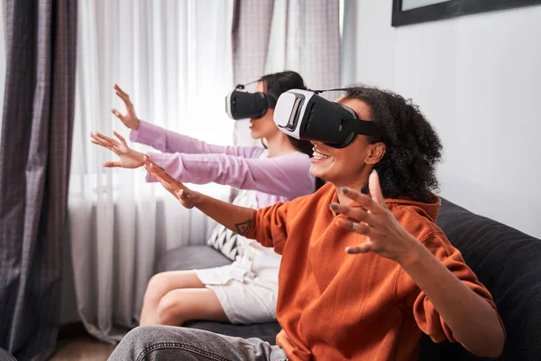 Mujer con dispositivo de tecnología VR sentado en el sofá — Foto de Stock