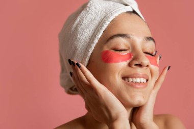 Yüzüne pembe bantlar yapıştıran bir kadın.