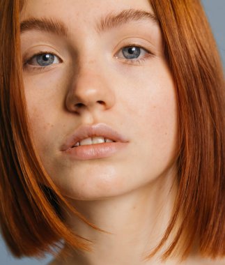 Kısa kızıl saçlı, ciddi bir kadın.