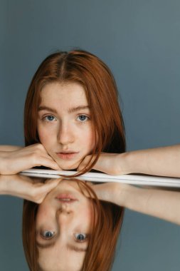 Ellerine başını tutarken masaya yansıyan kadın.