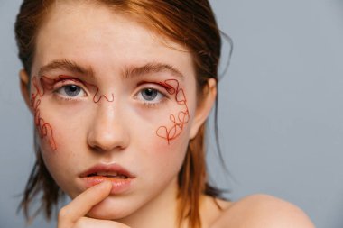 Kızıl saçlı kadın dudaklarını ısırıyor.