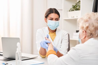 Klinikteki doktor nabız ve kalp atışlarını inceliyor.