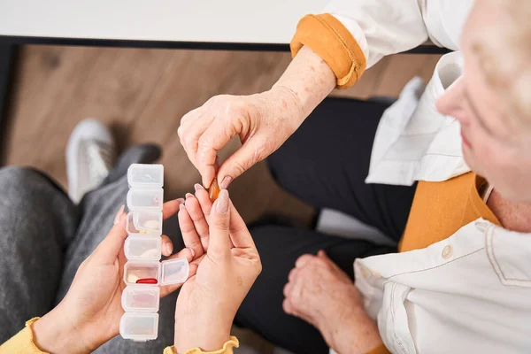 Medical worker explaining about pills to her patient