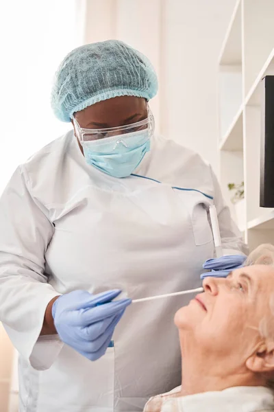 Lady sitting head thrown back during the PCR test