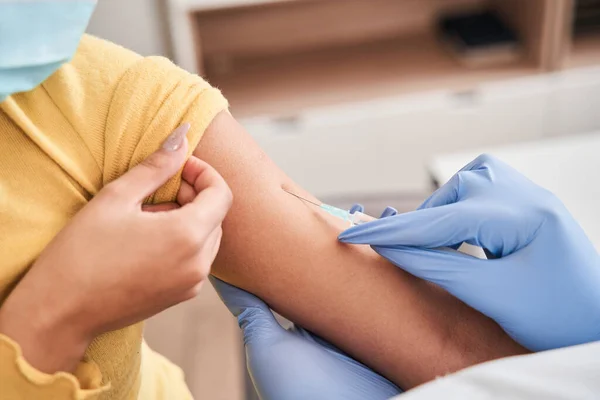 Caucasian woman receiving vaccine shot in hand