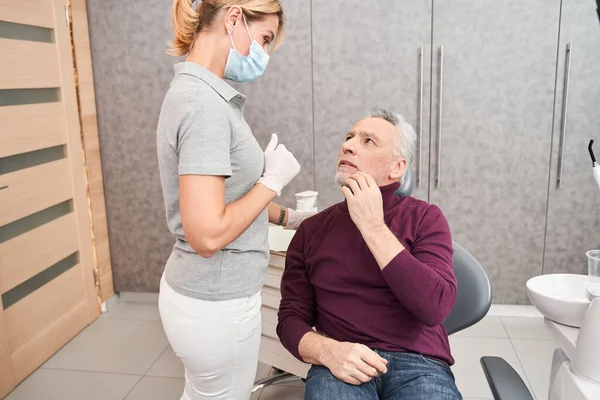 Upset man touching his cheek at the dentist
