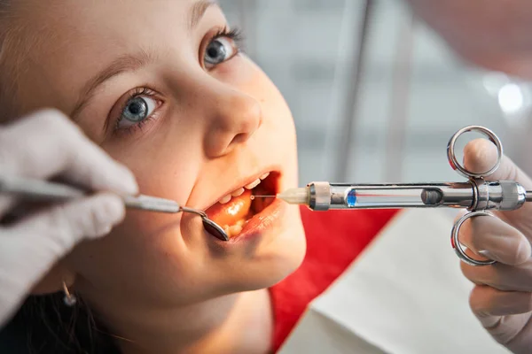 Girl getting local anesthesia injection into gums