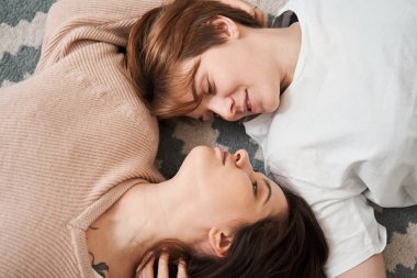 Birlikte romantik bir hafta sonu geçirirken yerde yatan lezbiyen çift.