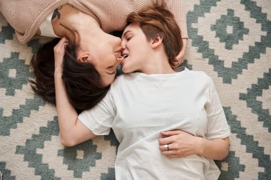 Kısa saçlı kadın, evdeki sevgili kız arkadaşının burnunu ısırıyor.