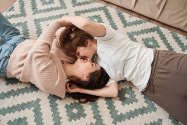 Yerde dinlenirken kız arkadaşını kucaklayan bir kadın.