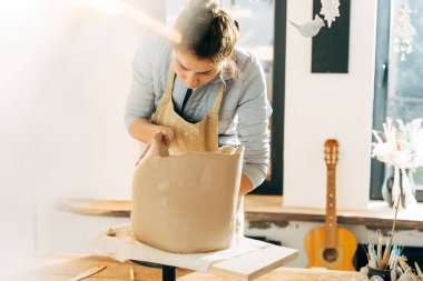 Mutlu çömlekçi çömlek masasında seramik demlik yapıyor.