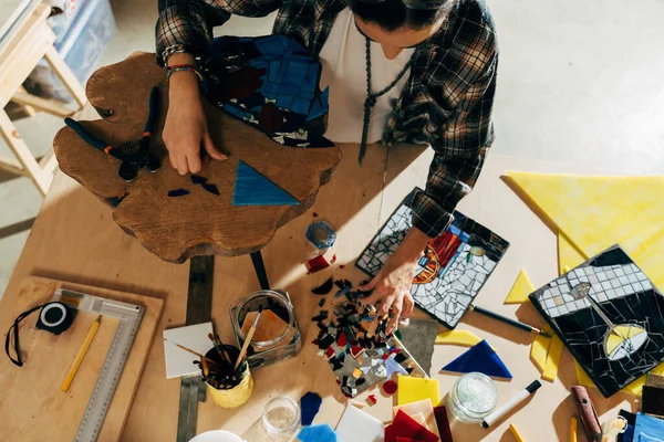 Artist choosing glass for the future panno while standing at the studio