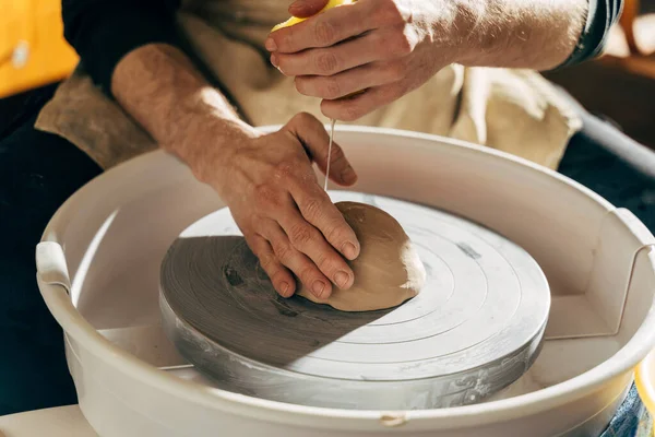 Potter makes pot of clay on potters wheel