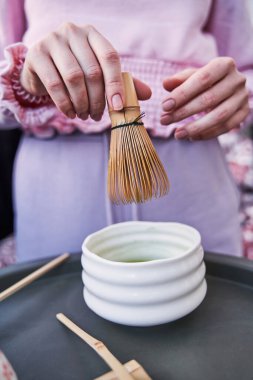 Balkondaki masada çay hazırlayan kadın.