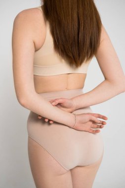 Kızıl saçlı, çilli, kollarını kavuşturmuş poz veren bir kadın.