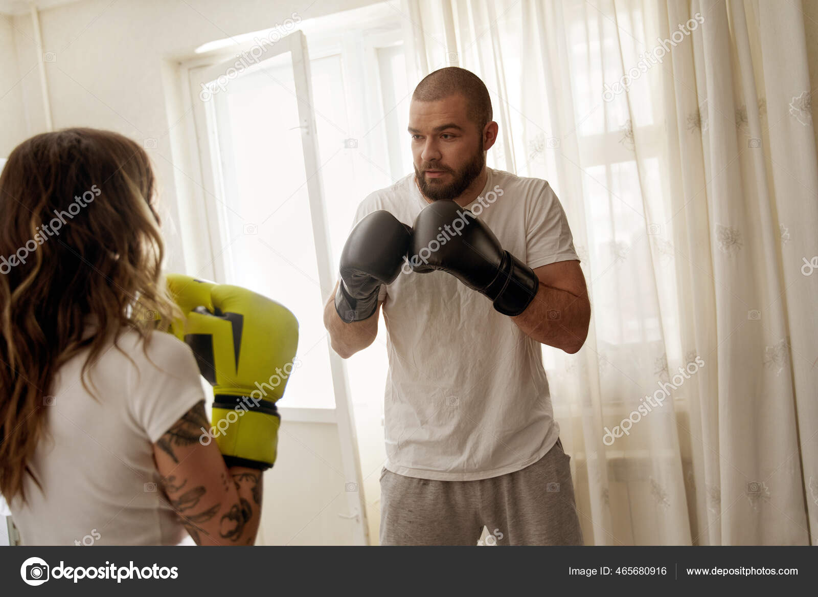 Man wearing gloves defend oneself while having boxing training with his wife Stock Photo by ©iakovenko123 465680916