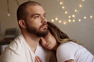 Birbirine aşık çiftler yatak odasında kucaklaşıp sarılıyorlar.