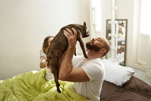 Hermosa pareja relajándose en casa y amando a su mascota — Foto de Stock