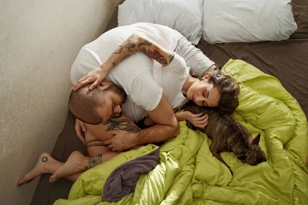 Σύζυγοι περνούν χρόνο με το σκύλο τους ενώ ξαπλώνουν στο κρεβάτι — Φωτογραφία Αρχείου