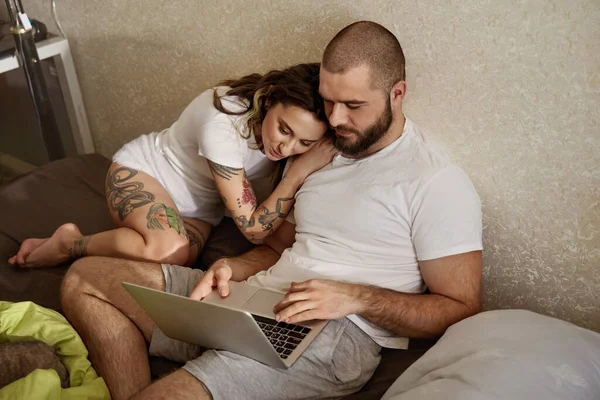 Kvinna tittar på något på laptopen med sin skäggiga pojkvän — Stockfoto