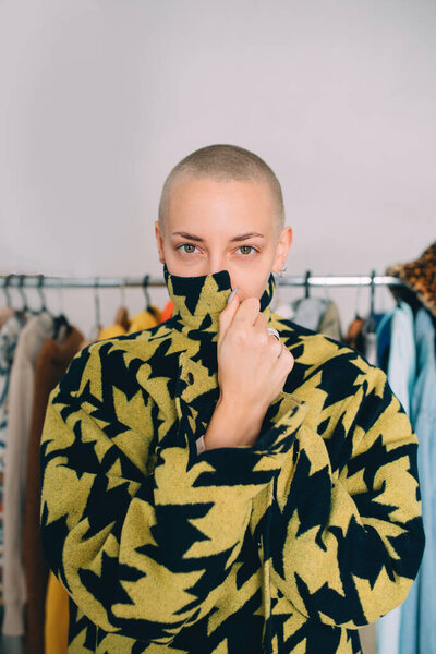 Woman with short hairstyle standing and wearing stylish coat while posing