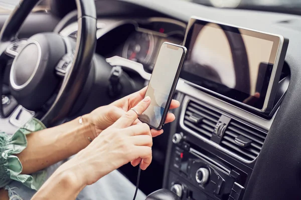 Mädchen aus nächster Nähe lädt Handy im Auto — Stockfoto