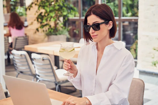 Praktisk affärskvinna i glasögon dricker cocktail — Stockfoto