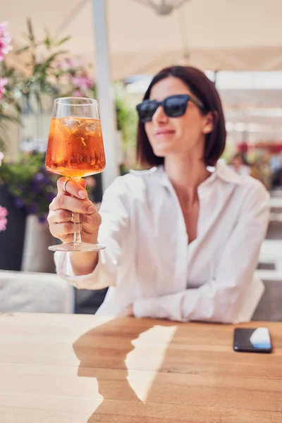 Chica atractiva bebiendo aperol en la terraza del restaurante —  Fotos de Stock