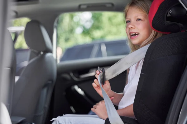 Happy little girl travelling in car seat — Stock Photo, Image