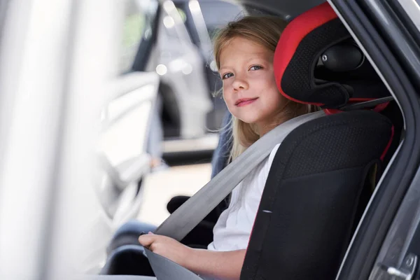 Sonriente hermoso niño en el asiento de seguridad del automóvil —  Fotos de Stock